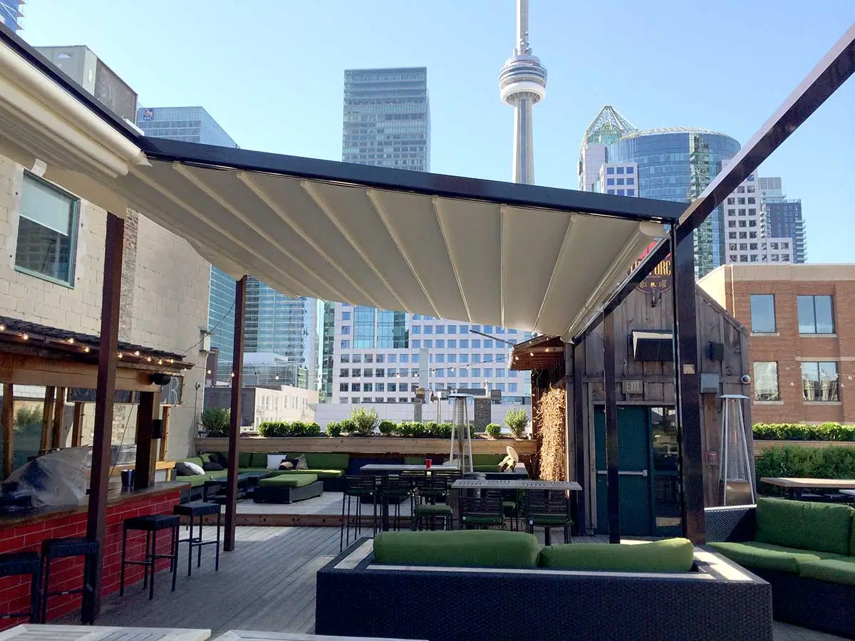 Corradi Palladia wall-mounted retractable pergola over an outdoor kitchen